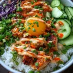 Four meal prep containers filled with spicy bang bang chicken, white rice, edamame, and cucumbers.