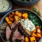 A vibrant meal prep bowl featuring sliced sirloin steak, roasted butternut squash cubes, and quinoa over fresh kale.