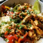 High-protein chicken fajita bowls with peppers, onions, black beans, and corn in meal prep containers.
