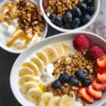 A creamy high protein yogurt bowl topped with crunchy granola, fresh blueberries, and a drizzle of almond butter.