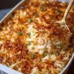 A golden, cheesy French Onion Chicken Rice Bake topped with crispy fried onions in a baking dish.