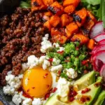 A bowl filled with white rice, glazed ground beef, steamed broccoli, and sesame seeds.