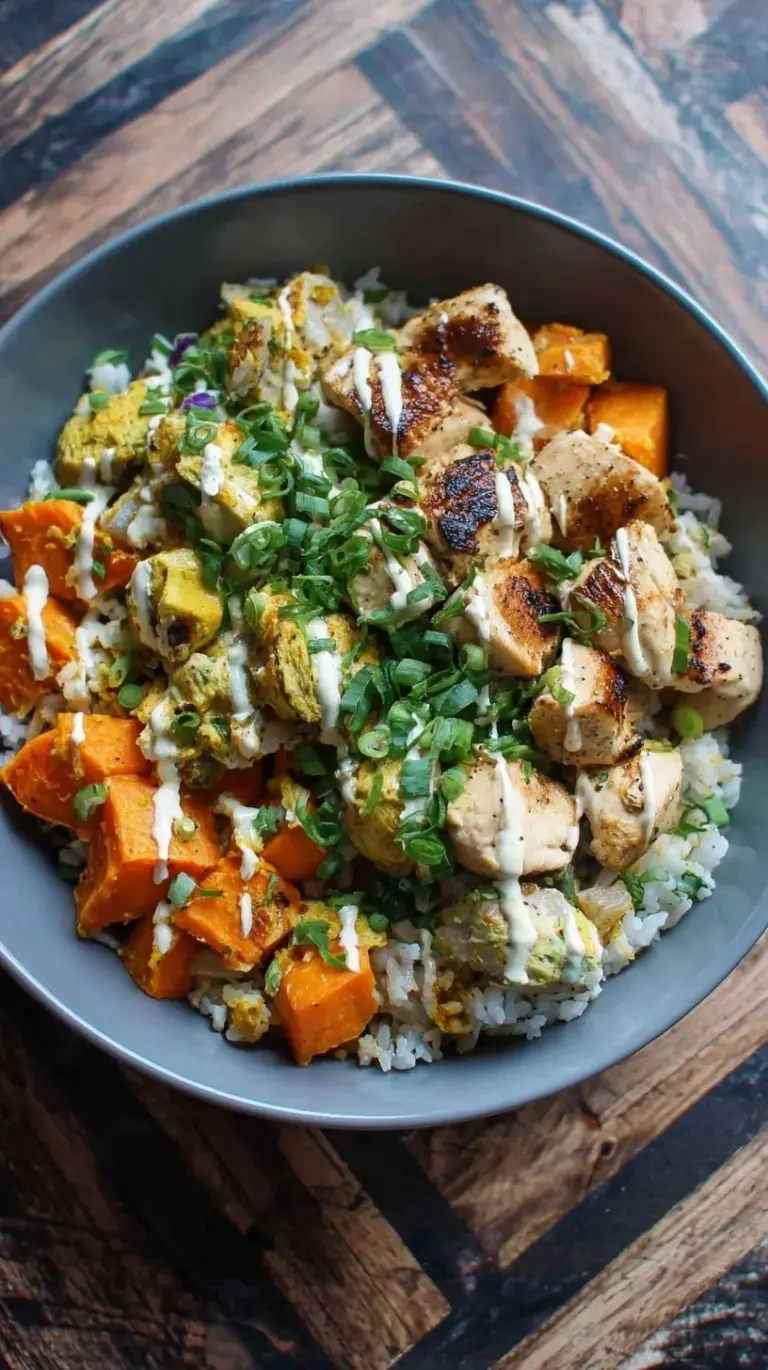 A colorful meal prep bowl with roasted chicken, cubed sweet potatoes, broccoli, and brown rice.