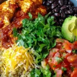 Four meal prep containers filled with chicken enchilada mixture over quinoa with melted cheese and cilantro.