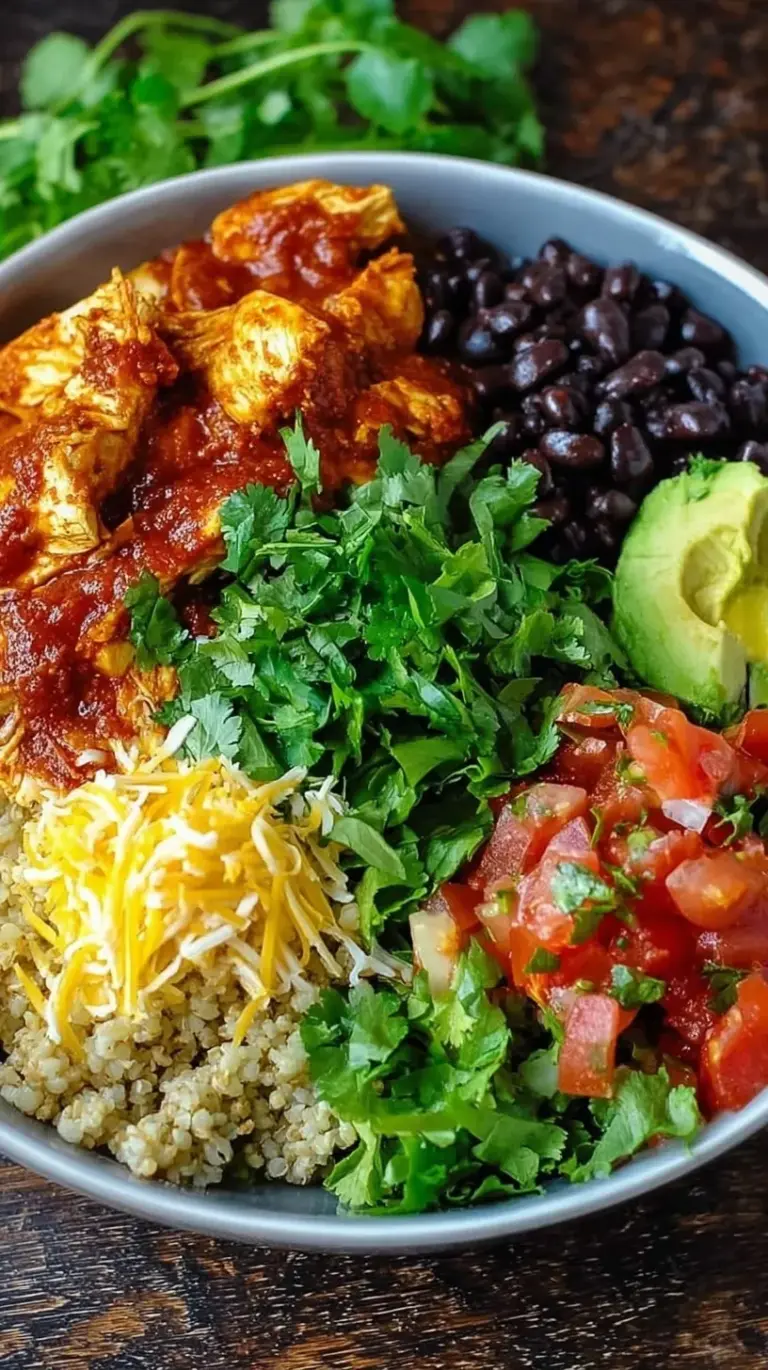 Four meal prep containers filled with chicken enchilada mixture over quinoa with melted cheese and cilantro.