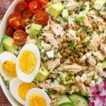 A vibrant bowl of High Protein Jennifer Aniston Salad with green herbs, chickpeas, and feta cheese