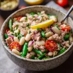 A bowl of high-protein tuna salad with white beans, cucumber, and fresh parsley