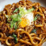 A bowl of steaming High Protein Yaki Udon with golden chicken and thick noodles