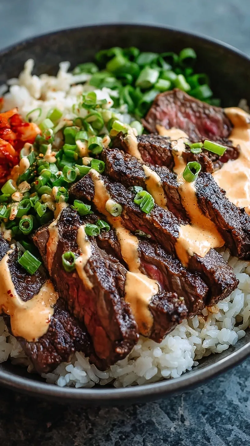 A vibrant bowl of seared steak, white rice, kimchi, and carrots with a creamy sauce drizzle.