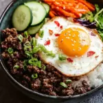 A savory Korean ground beef bowl topped with green onions and sesame seeds over white rice.
