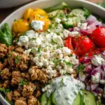 A colorful Mediterranean ground turkey bowl with quinoa, cucumbers, tomatoes, and feta cheese.