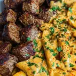 Seared Cajun steak tips served over creamy cheesy penne pasta with fresh parsley