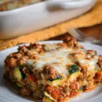A bubbling 9x13 baking dish filled with layers of zucchini, savory ground turkey, and melted golden mozzarella cheese.