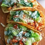 Golden brown smash chicken caesar tacos topped with fresh romaine and parmesan cheese.