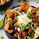 Crispy baked wonton taco bowls filled with glazed teriyaki chicken and fresh cabbage slaw on a serving platter.
