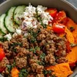 A colorful bowl with roasted sweet potatoes, taco beef, creamy cottage cheese, and avocado slices.